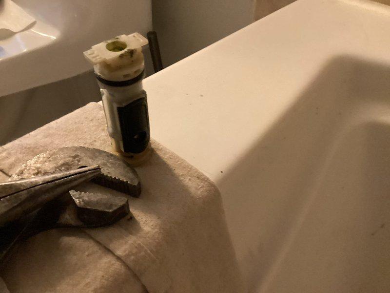 Responded to a Moen Posi-Temp shower valve failure where the handle hub assembly had seized on the stem, causing the cartridge stem to break during attempted removal. Accessed the valve from the rear wall opening and performed cartridge extraction to remove the broken stem and cartridge body that remained lodged in the valve housing. Installed new Moen Posi-Temp cartridge and completed trim kit installation with customer-supplied materials. Verified proper operation and confirmed no active leaks with water supply restored.