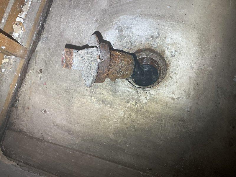 Responded to callback for new basement shower installation requiring underground drainage connection. Assessed existing 4" cast iron drain system showing significant corrosion and evaluated concrete floor conditions for proper drain tie-in. Documented heavily rusted standpipe assembly and existing floor drain opening with visible water staining indicating previous drainage concerns. Photographed newly installed shower pan with center drain assembly and surrounding wood framing to determine scope of underground piping work needed. Scheduled quality assurance specialist to provide detailed estimate for underground 4" cast iron drain line installation to connect new shower to existing drainage system.