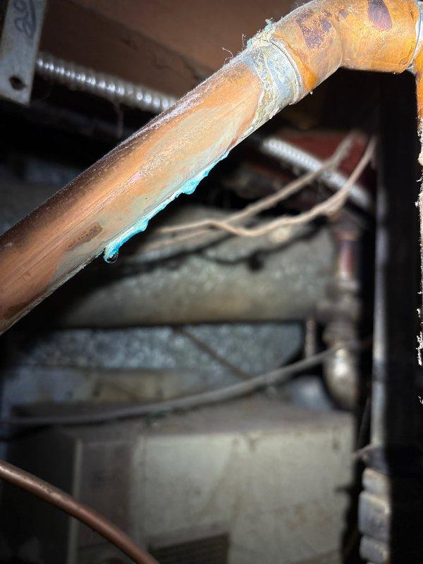 Upon arrival, discovered moisture on top of recently installed water heater. Further inspection revealed leak originating from an existing copper pipe fitting located just outside the scope of the original installation work. The problematic fitting showed signs of deterioration and was not part of the new water heater installation assembly. Documented the condition with photographs showing the copper piping configuration, connection points, and the source of the water intrusion. Scheduled follow-up visit to perform courtesy repair of the pre-existing fitting that was not identified during the initial installation.