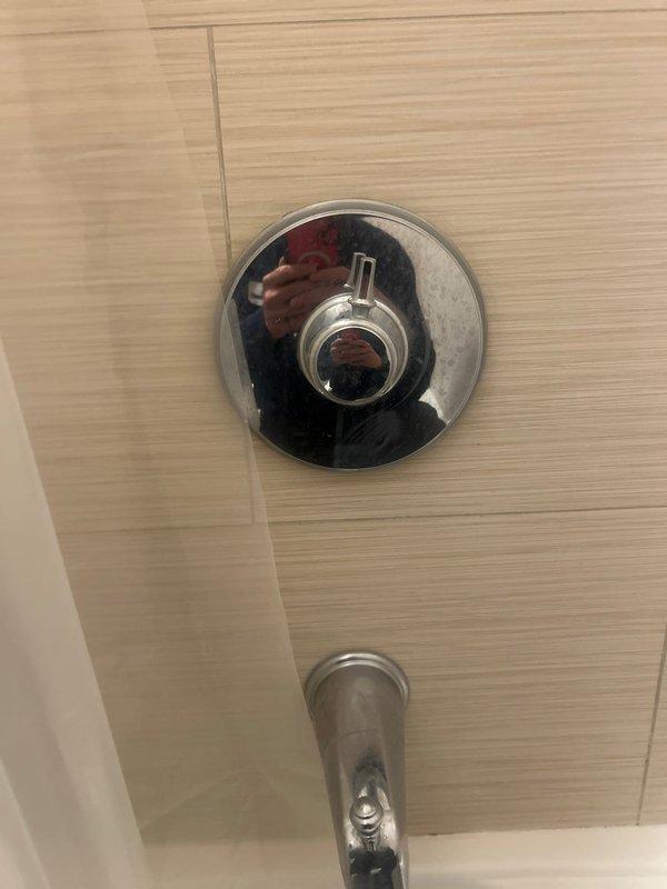 Responded to a shower leak affecting the ceiling of the unit below. Upon inspection, identified the shower mixer valve as the source of the water intrusion. Assessed the chrome shower control valve and fixtures mounted on the tile wall, documented the ceiling damage in the affected bathroom, and provided repair estimates to address the leaking mixer assembly and prevent further water damage to adjacent units.
