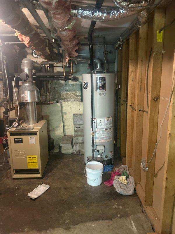 # Tanked Water Heater Installation

Successfully installed a new white tanked water heater in the basement mechanical room, replacing the previous unit. The installation included connecting supply and discharge piping, installing a temperature and pressure relief valve with proper discharge piping, and ensuring all connections met code requirements. All plumbing connections were tested for leaks and proper operation was verified before completing the service.