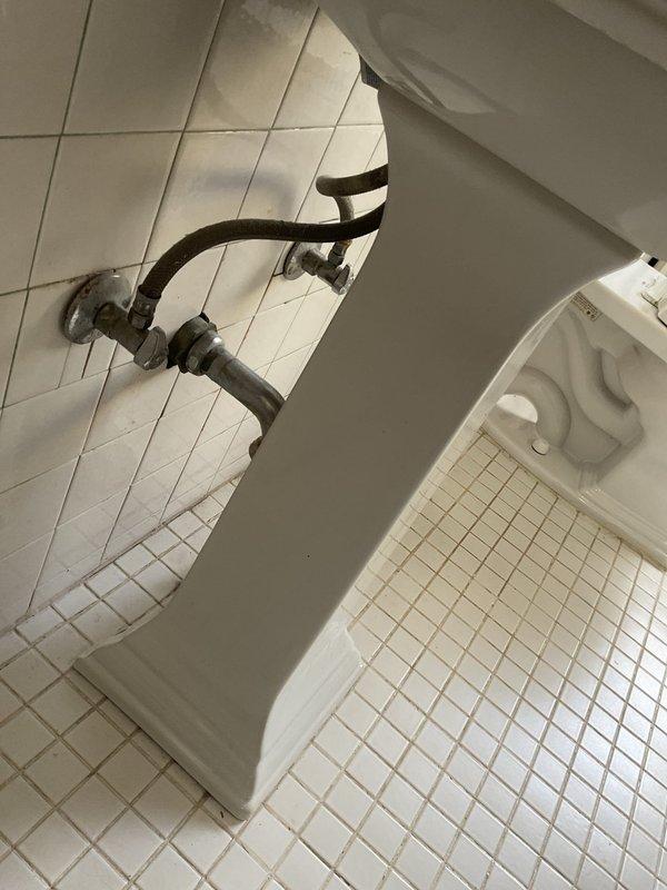 Responded to service call for multiple plumbing issues in 112-year-old residential property, including stopped toilet, clogged sink, and leaking toilet that had persisted for several months. Upon inspection, found vintage pedestal sink with chrome two-handle faucet and white porcelain toilet requiring attention. Cleared blockages from both toilet and sink drain lines using appropriate augering techniques for older plumbing systems. Addressed toilet leak by inspecting and servicing internal flush valve components and wax ring seal at floor connection. Evaluated existing brass/copper supply lines showing age-related tarnishing and oxidation, confirming proper function of wall-mounted shut-off valves. Due to advanced age of home's plumbing infrastructure, provided assessment of fixture conditions and drainage system performance. All fixtures restored to proper working order with adequate flow and drainage confirmed upon completion. Documented existing conditions of vintage plumbing compon