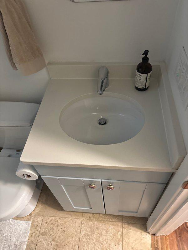 Responded to service call for bathroom vanity sink repair and water heater supply line issue. Upon inspection, assessed the undermount sink installation with chrome single-handle faucet and confirmed proper mounting and seal integrity. Examined water heater mechanical closet and inspected aged copper supply line connections showing oxidation and patina consistent with long-term use. Evaluated all plumbing connections at water heater top assembly, including vertical and angled copper runs, to identify potential leak points or deterioration requiring attention. Documented existing conditions of both fixtures for estimate preparation and recommended repairs to ensure continued safe operation of plumbing systems.
