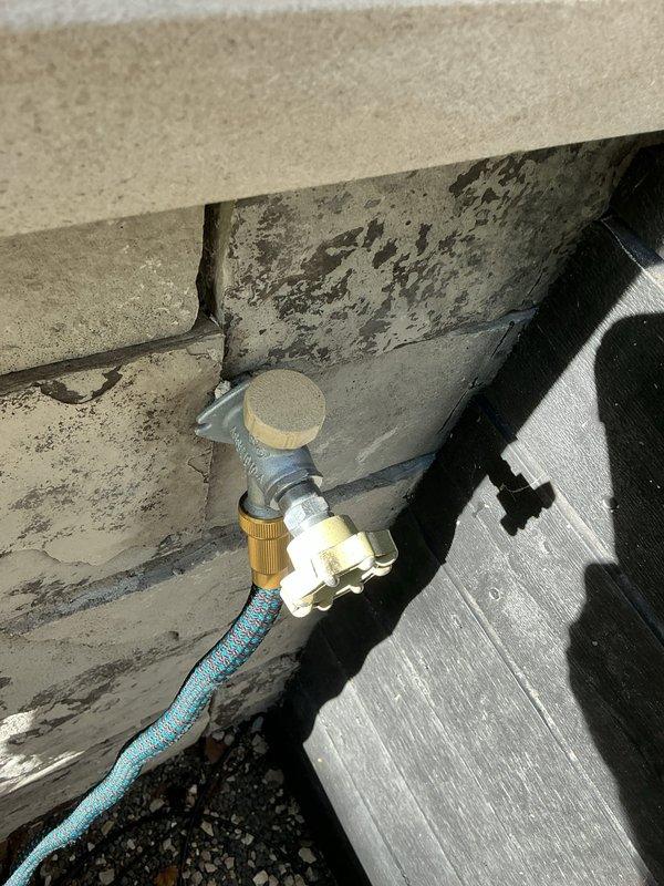 Responded to emergency call for outdoor spigot leaking into interior living space. Upon inspection, identified failed outdoor hose bib allowing water intrusion through foundation wall into unit. Accessed leak source through ceiling cavity to assess extent of water damage and confirm leak origin point. Replaced defective outdoor spigot with new frost-free sillcock, ensuring proper seal at foundation penetration to prevent future water intrusion. Tested installation under full water pressure to verify complete leak elimination and proper operation.