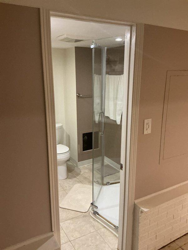 Conducted comprehensive residential drain and sewer system evaluation, including visual inspection of bathroom plumbing fixtures and assessment of accessible crawl space areas above living spaces. Documented existing plumbing infrastructure conditions, photographed shower enclosure, toilet installation, and overhead drainage routing through attic space to provide accurate estimate for potential drain and sewer service needs.