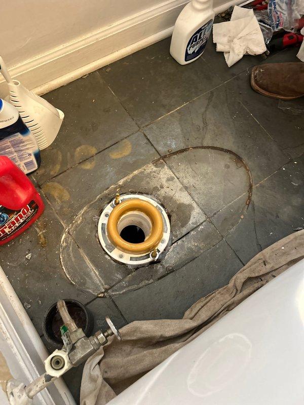 Responded to water leak investigation originating from first-floor powder room toilet causing visible plaster damage to basement ceiling below. Removed toilet to inspect flange assembly and discovered compromised wax ring seal with extensive water staining radiating across surrounding floor tiles, confirming active leak source. Documented significant ceiling deterioration in basement including sagging, delaminated plaster with multiple layers showing brown discoloration from prolonged moisture exposure. Diagnosed failed toilet seal as primary cause of water infiltration through floor assembly into ceiling cavity below.
