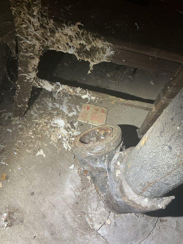 Conducted drain and sewer assessment at residential property to evaluate waste stack system requiring check valve installation. Inspection revealed aging plumbing infrastructure in basement area with vertical waste stack and horizontal piping connections showing signs of corrosion and deterioration. Documented existing conditions including compromised pipe components with rust accumulation and moisture exposure indicators, which necessitate the scheduled check valve installation to prevent backflow and ensure proper drainage system function.