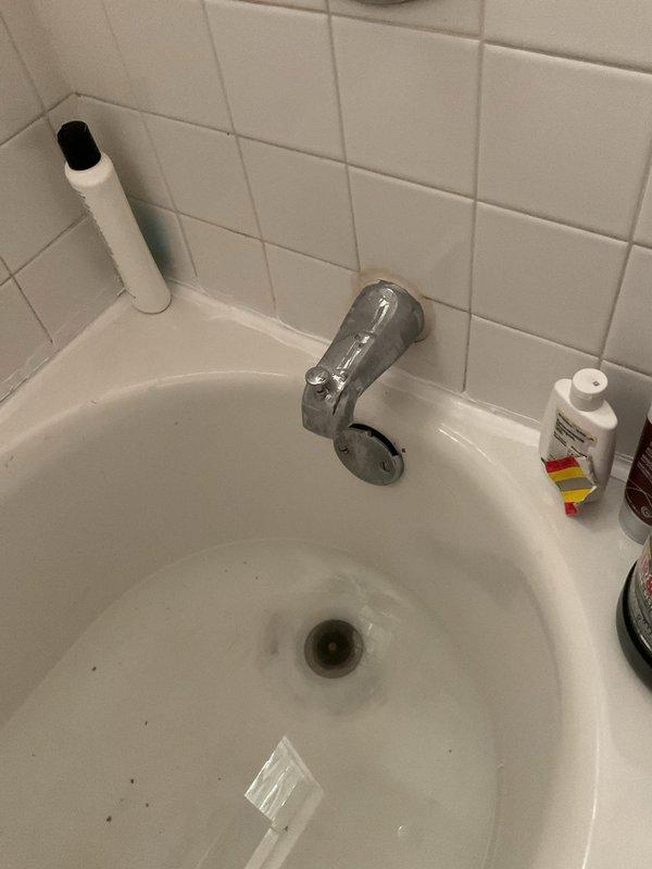 Responded to clogged bathroom sink drain call. Upon arrival, assessed the white porcelain sink with chrome single-handle faucet and identified slow drainage issue. Accessed the P-trap assembly beneath the sink from the cabinet below. Disassembled the white PVC P-trap configuration to remove accumulated debris and buildup causing the blockage. Cleared obstruction from trap and drain line, ensuring proper water flow. Reassembled P-trap connections with proper sealing, verified all fittings were secure and leak-free. Tested drainage by running water through the sink, confirming full flow restoration and proper trap function.