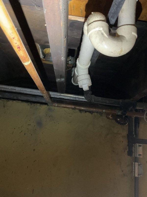 Responded to clogged bathroom sink drain call. Upon arrival, assessed the white porcelain sink with chrome single-handle faucet and identified slow drainage issue. Accessed the P-trap assembly beneath the sink from the cabinet below. Disassembled the white PVC P-trap configuration to remove accumulated debris and buildup causing the blockage. Cleared obstruction from trap and drain line, ensuring proper water flow. Reassembled P-trap connections with proper sealing, verified all fittings were secure and leak-free. Tested drainage by running water through the sink, confirming full flow restoration and proper trap function.