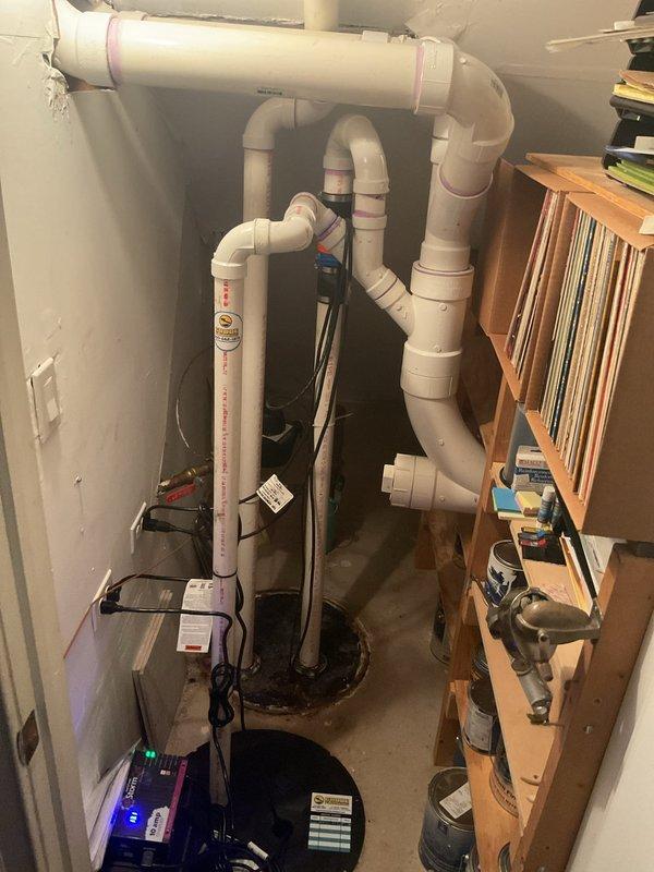 Responded to main drain backup causing water to rise in bathtub when toilet was flushed. Upon arrival, assessed plumbing system in fifteen-year-old home and located main drain cleanout access point in basement utility area. Performed mechanical augering of main sewer line to clear obstruction that had been causing drainage issues for approximately two weeks. Successfully removed blockage and restored proper flow through main drain system. Tested drainage by running multiple fixtures simultaneously to verify water was flowing correctly without backup into bathtub. Inspected existing sump pump system and associated PVC discharge piping configuration in basement to ensure proper operation and rule out any contributing factors to the drainage problem. Verified all plumbing components were functioning as designed following cleanout procedure. Documented equipment and piping layout with photographs for service records.