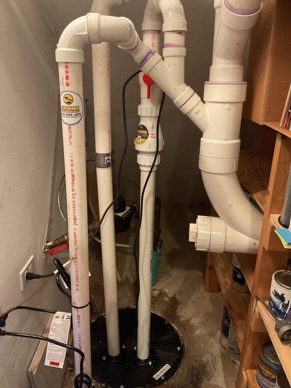 Responded to main drain backup causing water to rise in bathtub when toilet was flushed. Upon arrival, assessed plumbing system in fifteen-year-old home and located main drain cleanout access point in basement utility area. Performed mechanical augering of main sewer line to clear obstruction that had been causing drainage issues for approximately two weeks. Successfully removed blockage and restored proper flow through main drain system. Tested drainage by running multiple fixtures simultaneously to verify water was flowing correctly without backup into bathtub. Inspected existing sump pump system and associated PVC discharge piping configuration in basement to ensure proper operation and rule out any contributing factors to the drainage problem. Verified all plumbing components were functioning as designed following cleanout procedure. Documented equipment and piping layout with photographs for service records.