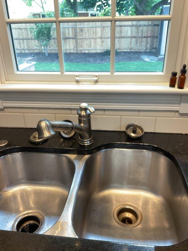 Installed customer-supplied kitchen faucet in double-basin stainless steel sink with brushed metal pull-out fixture and matching soap dispenser. Completed plumbing connections beneath sink using PVC P-trap assembly and copper supply lines with shut-off valves. Performed camera inspection of drainage system and resealed pit as requested to complete outstanding work from previous service.