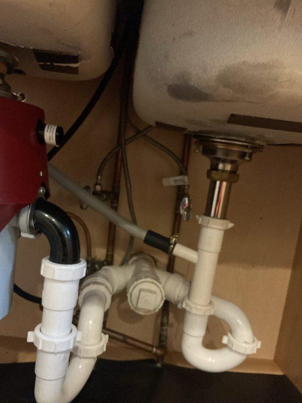 Installed customer-supplied kitchen faucet in double-basin stainless steel sink with brushed metal pull-out fixture and matching soap dispenser. Completed plumbing connections beneath sink using PVC P-trap assembly and copper supply lines with shut-off valves. Performed camera inspection of drainage system and resealed pit as requested to complete outstanding work from previous service.