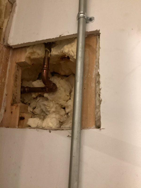 Completed VIP plumbing maintenance inspection involving water filtration system and concealed plumbing infrastructure. Accessed wall cavity to examine copper piping connections and insulation condition around plumbing runs. Inspected horizontal whole-house water filter assembly with clear canister housing, verified mounting bracket integrity, and assessed sediment accumulation within filter cartridge to ensure proper water treatment system operation.