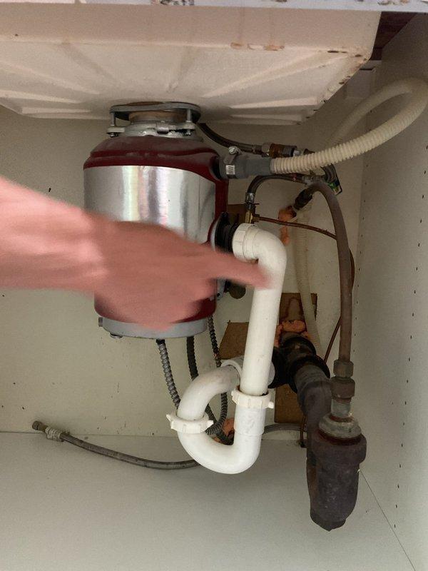 Removed existing garbage disposal unit from kitchen sink drain system and installed standard P-trap drain configuration to restore proper drainage. Cleared obstruction from bathroom sink drain line to ensure proper water flow. All plumbing connections were secured and tested for leaks, with the kitchen sink now functioning with a conventional drain assembly rather than the disposal unit.