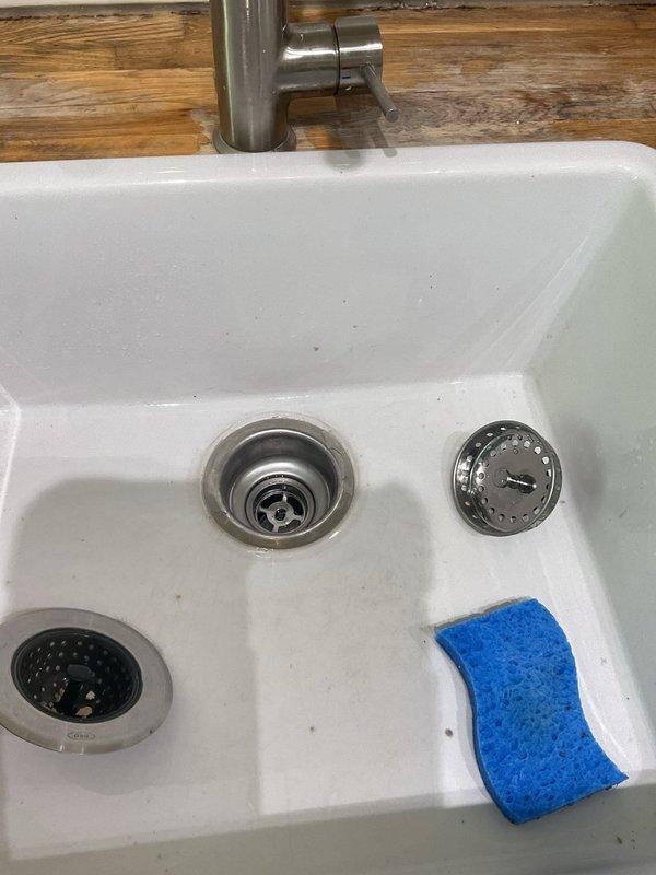 Removed existing garbage disposal unit from kitchen sink drain system and installed standard P-trap drain configuration to restore proper drainage. Cleared obstruction from bathroom sink drain line to ensure proper water flow. All plumbing connections were secured and tested for leaks, with the kitchen sink now functioning with a conventional drain assembly rather than the disposal unit.