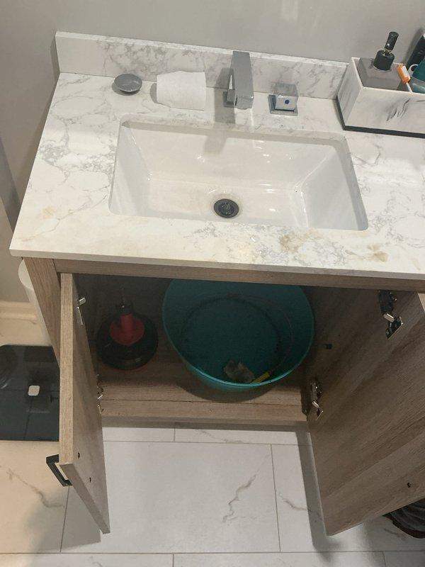Responded to under-sink plumbing concern at bathroom vanity. Upon inspection, identified active leak in P-trap assembly beneath undermount sink. Placed collection basin to contain water during diagnosis and repair. Disassembled drain piping, replaced faulty P-trap components, and reinstalled with proper sealing. Tested water flow and verified all connections are secure with no leaks present. System restored to full functionality.