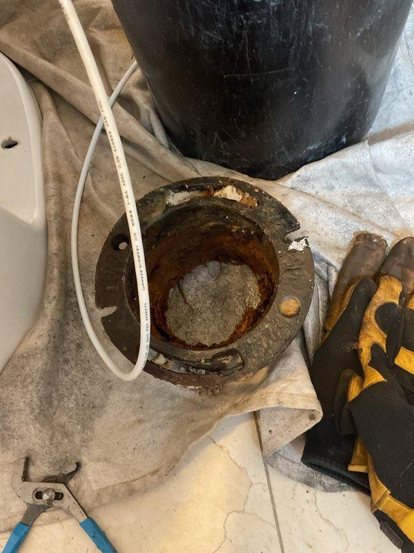 Replaced heavily corroded cast iron closet flange due to extensive rust deterioration that compromised the integrity of the toilet mounting system. Removed the existing deteriorated flange and installed a new black cast iron replacement flange with threaded collar, ensuring proper alignment and secure mounting to the drain pipe. The new fitting features a four-bolt mounting pattern and will provide a stable, leak-free connection for the toilet reinstallation.