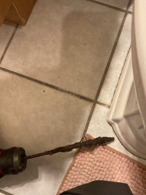 Responded to a clogged bathtub drain service call and successfully cleared the blockage using a drain auger. The plumbing snake was fed through the tub drain to break up and remove the obstruction, restoring proper drainage function. The work area was left clean with the bathtub operational and draining freely.