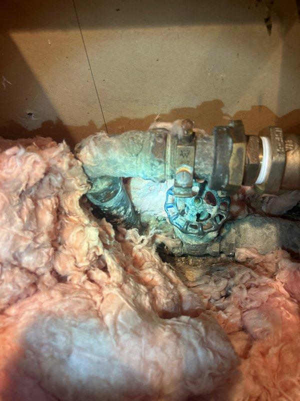 Conducted plumbing estimate inspection focusing on main water shutoff valve located in attic/crawl space. Evaluated existing gate valve showing significant corrosion and blue-green patina buildup on copper/brass components, indicating advanced oxidation from moisture exposure and age. Documented condition of aging plumbing infrastructure with photographic evidence. Assessed valve operability and determined replacement recommendation for main shutoff valve to ensure reliable water control and prevent potential failure. Coordinated neighbor notification prior to arrival as requested.