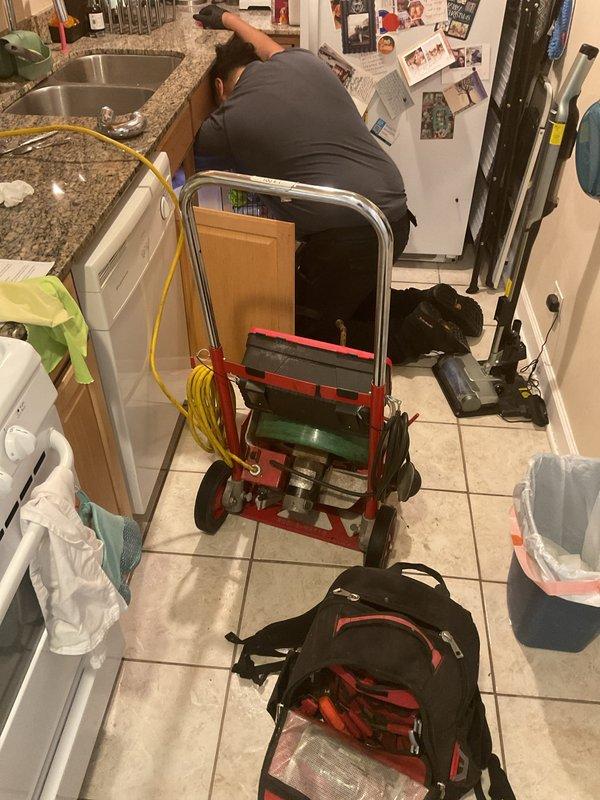 Responded to service call for standing water in double-basin kitchen sink and dishwasher. Upon arrival, confirmed both sink basins and dishwasher were filled with dirty water indicating a drainage obstruction in the common waste line. Deployed professional drain cleaning equipment including powered auger system to clear the blockage in the kitchen drain system. Successfully restored proper drainage function, allowing water to flow freely from both sink basins and dishwasher through the waste line.