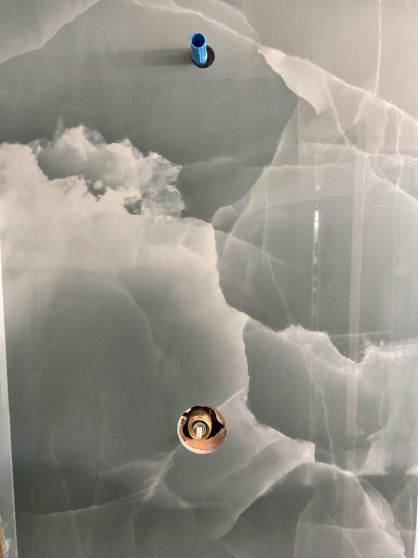 Conducted site assessment for shower fixture installation. Customer had showerhead assembly, handheld fixture, and handle trim parts on-site, but installation could not be completed due to missing shower arm and escutcheon in matching finish. Documented existing gold-tone handheld shower with flexible hose and wall bracket already installed. Explained to customer that additional components in correct finish are required before trim installation can proceed. Provided estimate for finish plumbing work to complete the fixture assembly.