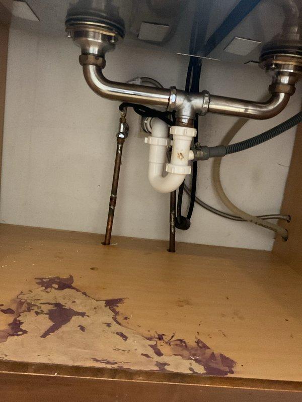 Responded to kitchen sink drainage issue in century-old home where homeowner had attempted P-trap cleaning but was unable to clear blockage completely or achieve proper reseal of the assembly. Upon inspection, found misaligned press-fit P-trap connections preventing proper seating and seal integrity. Disassembled white PVC P-trap assembly and chrome drain fittings, cleared remaining debris from trap and tailpiece, and realigned all connections to ensure proper fit and seal. Verified drainage flow, tested all connections for leaks, and confirmed P-trap reinstallation with appropriate water seal to prevent sewer gas entry.