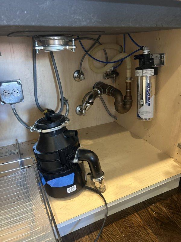 Responded to a kitchen sink leak caused by a failed P-trap assembly connected to the garbage disposal unit. Removed the damaged S-shaped drain pipe, inspected the disposal connection and cabinet plumbing system, and installed a new P-trap assembly with proper sealing. Verified all connections were secure, tested the system for leaks, and confirmed proper drainage function through both the sink and disposal unit.