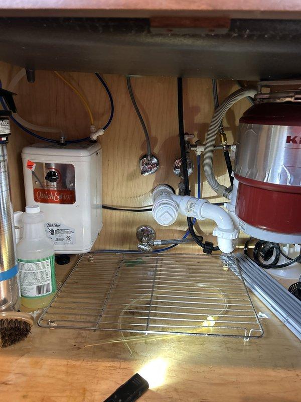 Installed new chrome gooseneck kitchen faucet with dual handles at island sink, connecting supply lines to existing shut-off valves and verifying proper water flow and drainage. All connections tested and confirmed leak-free with no issues detected in the existing under-sink plumbing configuration.