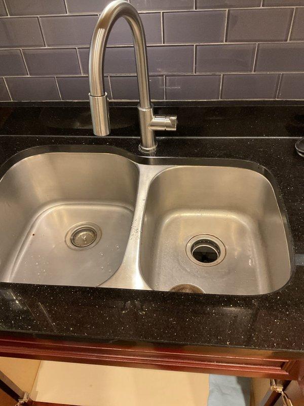 Responded to a clogged kitchen sink backup in a residential unit. Upon inspection, found the double-basin stainless steel sink experiencing drainage issues. Cleared the blockage from the drain line and verified proper water flow through both basins. Inspected the under-sink plumbing connections and main water supply system in the basement area to ensure no additional issues with the drainage system or related plumbing infrastructure.