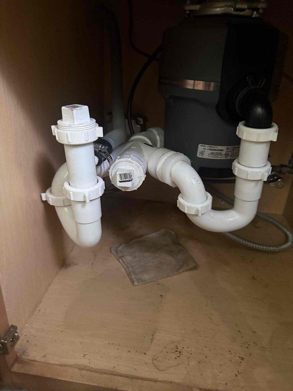 Responded to kitchen sink service call for reported cold water supply issues and faucet leak. Upon inspection, identified leak at faucet base and compromised cold water line connection. Disassembled single-handle brushed nickel faucet assembly to access supply lines and mounting hardware. Replaced worn cartridge seals and tightened supply line connections beneath sink. Verified proper drainage through existing PVC trap assembly and garbage disposal connection. Tested hot and cold water flow at full pressure, confirmed leak elimination, and ensured all connections were secure with no drips. System restored to full operational status.