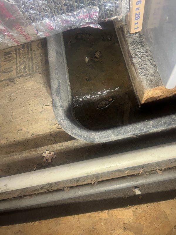 Investigated water stain complaint related to outdoor spigot supply line. Located leaking pipe in basement ceiling by creating access opening through drywall. Identified compromised supply line serving exterior spigot, which had been causing water infiltration and ceiling damage. Exposed affected area revealed standing water in drainage pan and multiple pipe runs requiring assessment. Documented conditions with photos showing extent of water damage and pipe configuration for repair recommendations.