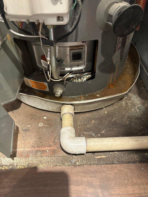 Responded to no hot water complaint with LCD error code 13 displayed on tanked water heater. Upon inspection, discovered significant water leakage from tank body with rust-colored water accumulation in drip pan and visible corrosion streaking down exterior of unit. Identified failed tank integrity as root cause of error code and loss of hot water. Documented extensive water damage and corrosion around copper pipe penetration point and base of unit. Advised that water heater has reached end of service life and requires complete replacement due to tank failure. Unit deemed unsafe for continued operation.