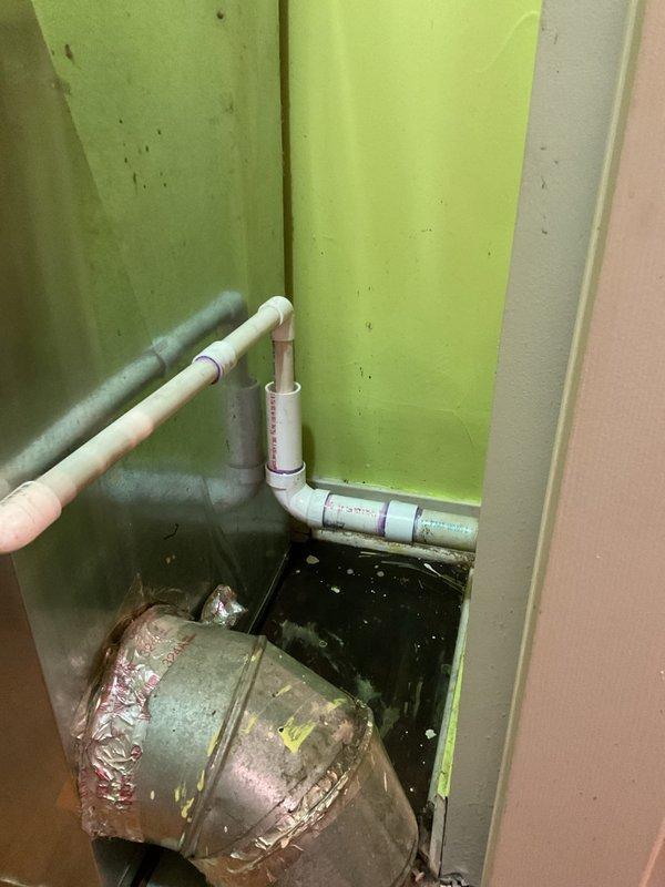 Responded to a water leak investigation in a basement storage area where persistent dripping was reported from the ceiling, suspected to originate from a bathroom above. Upon inspection, identified multiple plumbing lines including PVC drain pipes, supply lines, and HVAC ductwork in the affected area with visible moisture accumulation on surfaces and flooring. Documented the plumbing configuration and condition of exposed pipes, connections, and mechanical components to determine the source of the leak and provide recommendations for repair.
