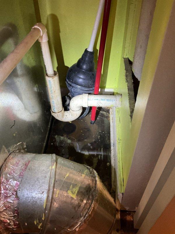 Responded to a water leak investigation in a basement storage area where persistent dripping was reported from the ceiling, suspected to originate from a bathroom above. Upon inspection, identified multiple plumbing lines including PVC drain pipes, supply lines, and HVAC ductwork in the affected area with visible moisture accumulation on surfaces and flooring. Documented the plumbing configuration and condition of exposed pipes, connections, and mechanical components to determine the source of the leak and provide recommendations for repair.