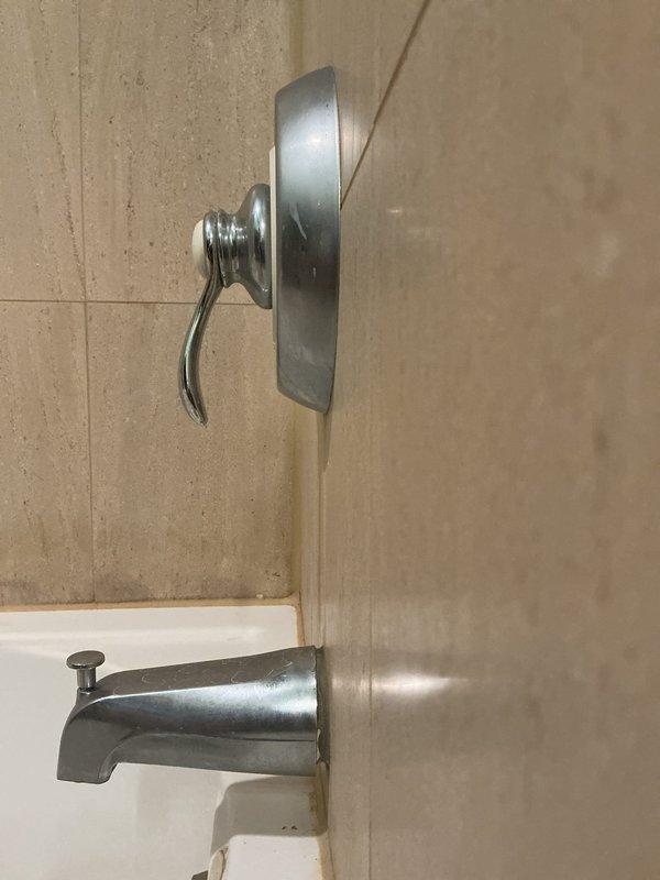 Responded to service call for malfunctioning tub spout diverter mechanism. Upon inspection, found the pull-up diverter pin on the chrome tub spout was disconnected and no longer engaging to redirect water flow from tub spout to shower head. Assessed the existing fixture assembly including the single-handle shower valve and tub spout mounted on tiled wall. Provided estimate for diverter repair or complete tub spout replacement to restore proper water flow switching functionality between tub and shower modes.