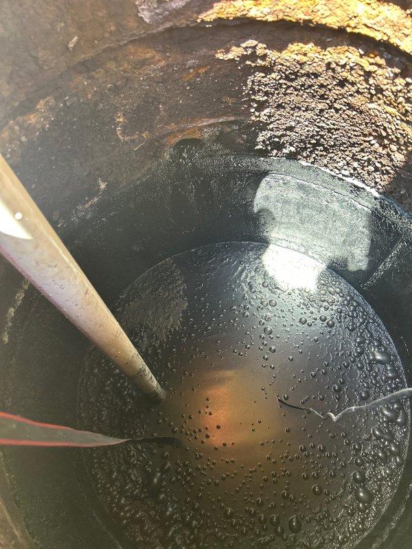Responded to residential property experiencing multiple sewer backup issues. Accessed main sewer line through exterior cleanout pit, which exhibited severe corrosion and rust on metal rim components indicating long-term moisture exposure. Performed visual inspection of underground sewer infrastructure, documenting heavily deteriorated conditions including stagnant water with debris accumulation, algae growth, and mineral deposits throughout the access point. Recommended implementation of annual sewer maintenance program to prevent future emergency backup situations and address ongoing drainage concerns within the building's sewer system.
