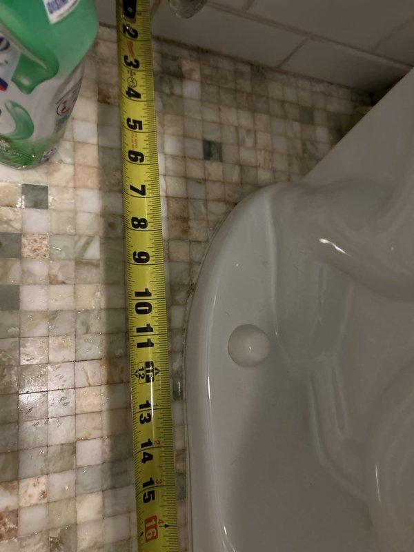 Responded to a toilet base leak in a basement unit bathroom. Upon inspection, found active water seepage at the toilet base with visible water staining and discoloration on the surrounding mosaic tile floor. Documented measurements and assessed the condition of the wax ring seal and flange connection. The leak pattern indicated a compromised seal between the toilet base and the drain flange, requiring toilet removal and reinstallation with new wax ring and hardware to restore proper watertight seal and prevent further water damage to the flooring.
