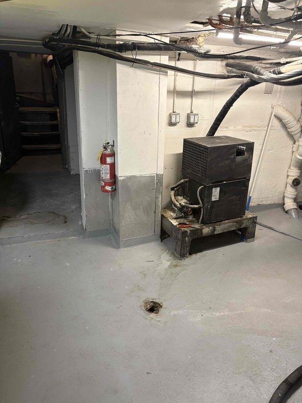 Performed comprehensive camera inspection and documentation of residential basement mechanical systems. Documented heating system installation including floor-mounted components with PVC venting, extensive copper piping network with circulator pump, control systems, and electrical connections. Captured HVAC condensing unit positioned on wooden platform with associated refrigerant lines, ductwork, and utility room infrastructure including fire safety equipment and drainage systems.