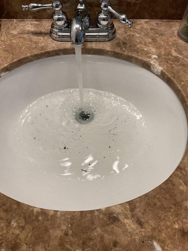 Responded to master bathroom sink drain clog causing water backup and overflow conditions. Accessed P-trap assembly beneath vanity sink and performed diagnostic inspection of drainage system. Cleared obstruction from drain line, reassembled plumbing components, and tested system to verify proper water flow and drainage functionality restored.