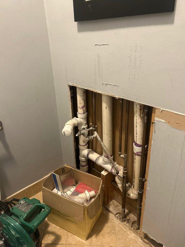 Completed plumbing rough-in installation for interior renovation project, routing copper supply lines and PVC drain/waste/vent piping through exposed wall framing. Installed vertical and horizontal pipe runs with proper fittings, elbows, and junction connections in accordance with code requirements, preparing the system for inspection and subsequent drywall closure.