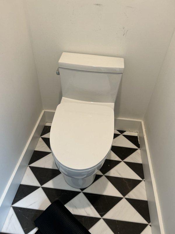 Responded to report of toilet leak causing water damage and ceiling staining on the floor below. Upon inspection, identified active leak at toilet base allowing water to seep through flooring into the space beneath. Removed toilet from flange, inspected wax ring and found it deteriorated and no longer providing proper seal. Cleaned flange area, scraped away old wax residue, and verified flange integrity and proper mounting. Installed new wax ring with plastic horn for improved seal, reset toilet to flange ensuring proper alignment and level positioning, and torqued closet bolts to manufacturer specifications. Tested toilet with multiple flush cycles and verified no leakage at base connection. Advised monitoring ceiling below for any further moisture development, though leak source has been eliminated with wax ring replacement.