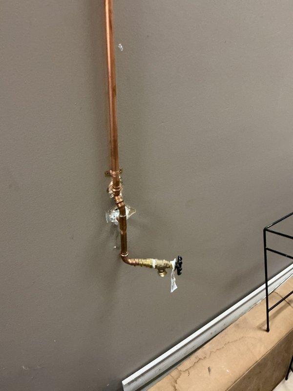 Responded to water leak reported inside residential property. Upon arrival, located source of leak at copper water supply line with compromised brass fitting connections. Inspected vertical pipe run along interior wall and identified failed valve assembly with damaged seal causing active water seepage. Shut off main water supply and drained affected line section. Removed defective brass fittings and valve components, cleaned copper pipe ends, and installed new shutoff valve with proper brass compression fittings. Verified exterior hose bib connection at brick wall perimeter for potential secondary leak points as part of comprehensive system check. Tested all connections under full pressure, confirmed no leaks present at repair site or related plumbing fixtures. Restored water service and documented completed repairs with photographic evidence. System operating properly at time of departure.
