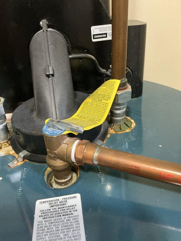 Performed routine maintenance flush on residential tanked water heater located in condo unit. Drained sediment buildup from tank bottom through drain valve, inspected temperature and pressure relief valve for proper operation, and verified all plumbing connections for leaks. Unit showed normal wear consistent with age, with pressure relief valve and copper supply lines in serviceable condition. System refilled, checked for proper heating operation, and confirmed water heater is functioning within normal parameters.