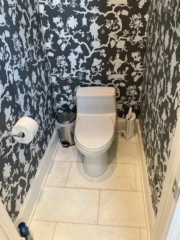 Removed existing garden hose connection and installed timer at outdoor spigot located under narrow deck in back of house. Inspected two toilets as requested; opened tank on TOTO unit to examine internal flush mechanism including float valve and flush valve assembly for proper operation.
