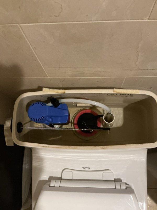 Removed existing garden hose connection and installed timer at outdoor spigot located under narrow deck in back of house. Inspected two toilets as requested; opened tank on TOTO unit to examine internal flush mechanism including float valve and flush valve assembly for proper operation.