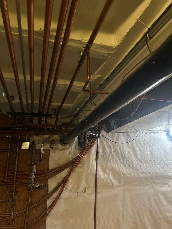 Conducted comprehensive plumbing assessment identifying multiple system concerns requiring attention. Evaluated existing sump pump and determined replacement necessary due to operational failure. Inspected main sewer line and recommended power rodding and flushing to address drainage issues. Assessed water quality needs and provided estimate for whole home filtration system installation at main water valve location. Documented existing mechanical room infrastructure including current water treatment equipment, copper supply lines, HVAC ductwork, and utility space configuration to support proposed system upgrades.