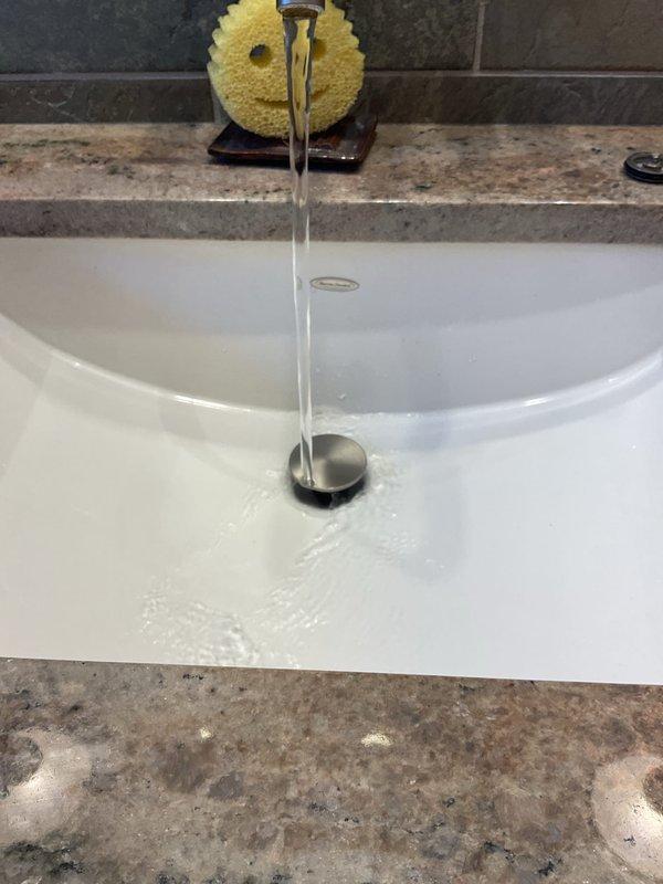 Replaced kitchen sink P-trap assembly with new white PVC piping and slip-joint fittings. Tested drain system for proper flow and verified no leaks at connections. System operating correctly with clear water drainage confirmed.