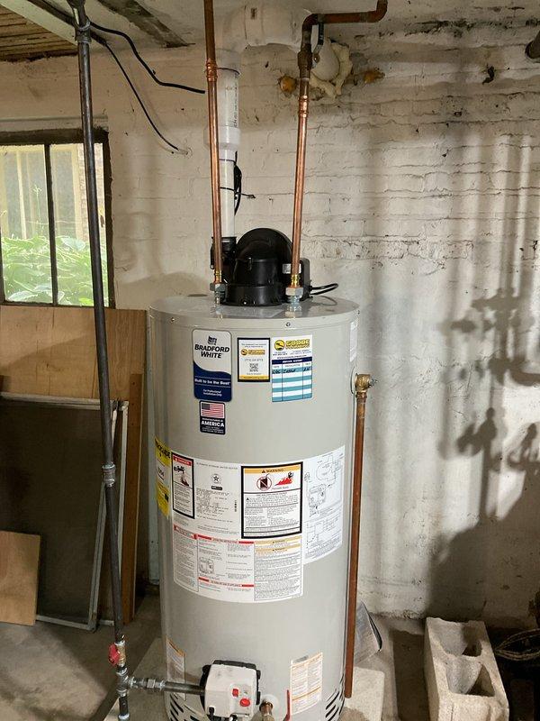 Completed installation of Bradford White tanked water heater in basement utility area. Installed new unit with proper copper supply line connections and brass shutoff valves at the top of the tank. Established electrical connections with appropriate wiring to power the heating elements and control mechanisms. Installed drain valve at base of unit with proper access for future maintenance. Secured all plumbing connections according to code requirements and verified proper operation of the water heating system upon completion.