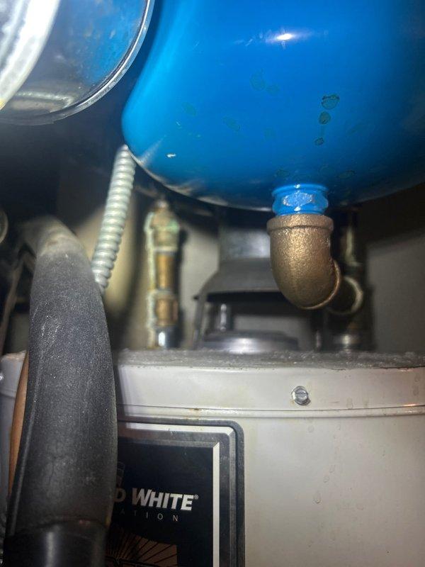 Responded to building-wide hot water outage affecting residential property. Upon arrival, inspected 5-year-old tanked water heater located in first-floor hallway utility closet. Performed diagnostic assessment of unit, examining anode rod condition, gas connections, pilot light assembly, and thermocouple function. Verified proper gas supply and electrical connections to unit. Inspected all visible plumbing connections, including brass fittings, shut-off valves, and supply lines for signs of corrosion or failure. Tested temperature and pressure relief valve operation and examined expansion tank connections. Documented equipment condition with photographs showing water heater installation, surrounding HVAC equipment, and detailed views of lower plumbing connections including blue expansion tank and brass fittings. Restored hot water service to building. Unit operational at time of departure.